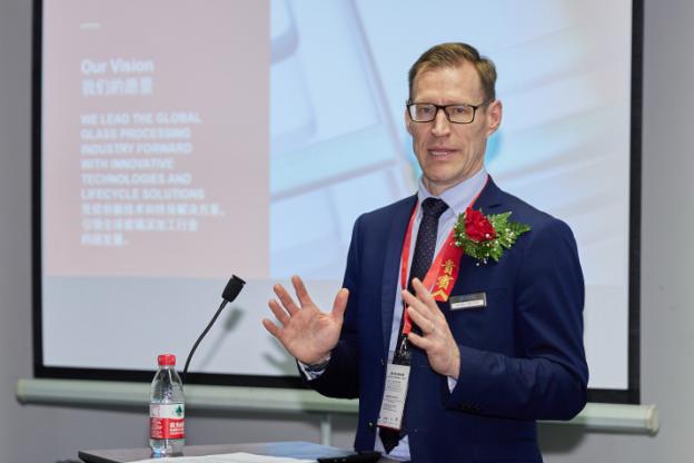 A person in a suit speaking at a podium

Description automatically generated with low confidence