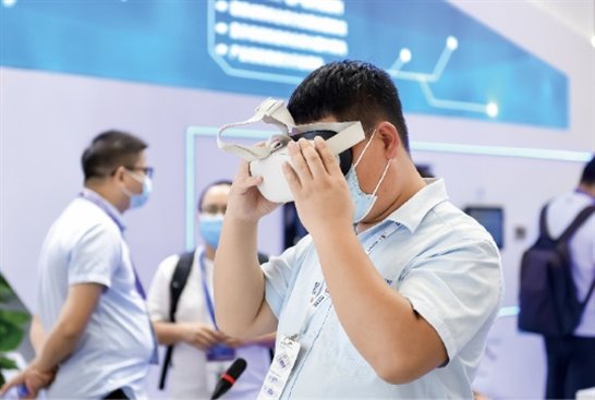 A person wearing a mask and holding a virtual reality goggles

Description automatically generated