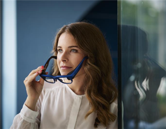 A person holding her glasses to her face
Description automatically generated
